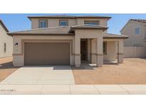 Charming two-story home featuring a well-manicured lawn and a cozy front porch at 15151 W Gray Fox Trl, Surprise, AZ 85387