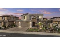 Beautiful home features a neutral color palette, brick driveway, three car garage and professionally designed desert landscaping at 10792 W Whitehorn Way, Peoria, AZ 85383