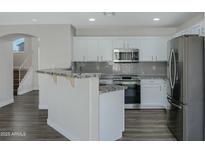 Modern kitchen featuring white cabinetry, stainless steel appliances, and a granite countertop breakfast bar at 15346 W Hearn Rd, Surprise, AZ 85379
