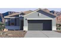 Charming single-story home showcasing a two-car garage, desert landscaping and mountain views at 1854 W Sombra Ave, Apache Junction, AZ 85120