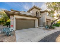 Two-story townhouse with a two-car garage, stone accents, and desert landscaping, showcasing its curb appeal at 20121 N 76Th St # 2064, Scottsdale, AZ 85255