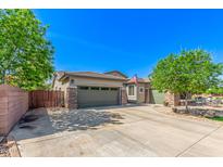 Inviting home featuring a three-car garage, a well-manicured yard, and attractive stone accents at 579 E Mary Ct, Gilbert, AZ 85295