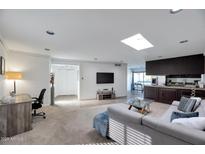 Open living room features a skylight, carpet flooring, and access to a kitchen area at 6240 N 16Th St # 45, Phoenix, AZ 85016