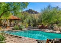Stunning pool area with a mountain view, covered patio, lounge chairs, and desert landscaping at 6301 N Camelback Manor Dr, Paradise Valley, AZ 85253