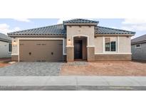 Charming single-story home with a gray tile roof, a two-car garage, and a covered entryway at 26949 W Lone Cactus Dr, Buckeye, AZ 85396
