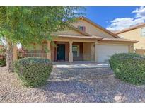 Charming single-story home featuring a covered porch, a well-manicured lawn, and an attached two-car garage at 11590 W Cocopah St, Avondale, AZ 85323