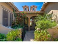 Charming front entrance with lush landscaping, tiled roof, and beautiful blooming vines at 18575 E Pine Barrens Ave, Queen Creek, AZ 85142