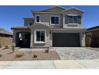 Charming two-story home featuring a gray stucco exterior, a two-car garage, and a beautifully paved driveway at 21830 E Bonanza E Ct, Queen Creek, AZ 85142