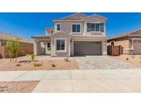 Two story home featuring a two car garage and a covered front porch, set against a clear blue sky at 21830 E Bonanza E Ct, Queen Creek, AZ 85142