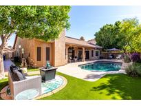 Backyard featuring a pool, patio, and artificial turf landscaping at 2226 E Beachcomber Dr, Gilbert, AZ 85234