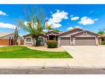 Charming single-story home with a well-manicured lawn, mature trees, and a spacious three-car garage at 2698 E Carla Vista Dr, Gilbert, AZ 85295