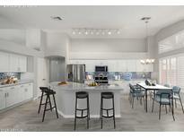 Staged kitchen with island, stainless steel appliances, tile backsplash, and dining area at 2698 E Carla Vista Dr, Gilbert, AZ 85295