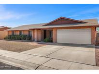 Charming brick home featuring a two-car garage, low maintenance yard, and inviting entryway at 5741 W Purdue Cir, Glendale, AZ 85302