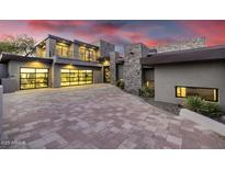 Modern home featuring stone accents, a glass garage door, and a spacious driveway at 9127 N Fireridge Trl, Fountain Hills, AZ 85268