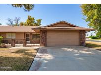 Single-story home featuring a brick facade, two-car garage, and well-maintained landscaping at 15462 N Lakeforest Dr, Sun City, AZ 85351