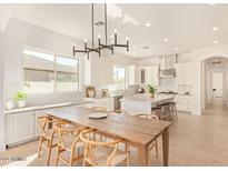 Bright, spacious kitchen with stainless appliances, central island, and adjacent dining area at 19162 E Mockingbird Dr, Queen Creek, AZ 85142