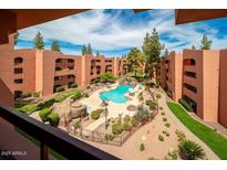 Exterior shot from above of the community pool with buildings, rocks, plants, and trees surrounding it at 4303 E Cactus Rd # 407, Phoenix, AZ 85032