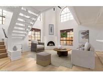 Bright living room with fireplace, high ceilings, hardwood floors, and staircase at 8845 S 48Th St # 1, Phoenix, AZ 85044