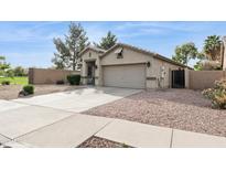 A single-story house with a neutral-colored exterior, a two-car garage, and low-maintenance gravel landscaping at 10605 W Windsor Ave, Avondale, AZ 85392