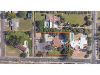 Expansive aerial view showcasing a charming neighborhood with mature trees and a sparkling blue pool on a sunny day at 1522 W Myrtle Ave, Phoenix, AZ 85021