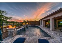 Inviting pool with fire features and stone accents, perfect for outdoor relaxation at sunset at 18233 W Hope Dr, Goodyear, AZ 85338