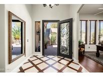 Elegant foyer featuring custom tile flooring, decorative iron door, and a view to the outdoor courtyard at 21235 N 80Th Way, Scottsdale, AZ 85255