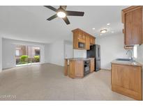 Open kitchen featuring wood cabinets, granite counters, stainless steel appliances, and a breakfast bar at 4554 E Paradise Village Pkwy # 161, Phoenix, AZ 85032