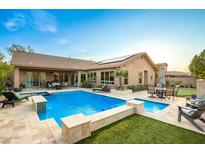 Backyard oasis featuring a sparkling pool, spa, lush greenery, and comfortable seating areas for outdoor relaxation at 5528 W Mine Trl, Phoenix, AZ 85083