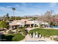 Expansive property showcases well-manicured lawns, a pool, and a charming outdoor lounge area at 7635 E Sweetwater Ave, Scottsdale, AZ 85260
