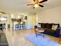 Inviting living room flows into updated kitchen with breakfast bar seating and natural light at 8055 E Thomas Rd # G101, Scottsdale, AZ 85251