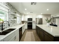 Modern kitchen featuring white cabinets, stainless steel appliances, decorative backsplash and spacious countertops at 8115 E Cypress St, Scottsdale, AZ 85257