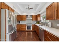 Modern eat-in kitchen features stainless steel appliances, wooden cabinetry and white countertops at 8424 E Via De Viva Dr, Scottsdale, AZ 85258
