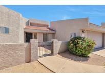 Inviting gated front entrance with desert landscaping leading to the front door and attached garage at 876 W El Monte Pl # 3, Chandler, AZ 85225