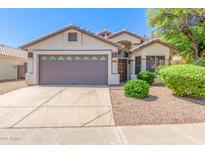 Charming home with a well-manicured front yard, mature landscaping, and a two-car garage at 1701 E Countrywalk Ln, Chandler, AZ 85225