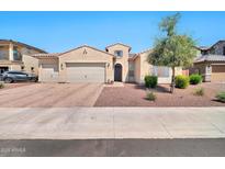Inviting single-story home featuring a three-car garage and well-maintained desert landscaping at 18394 W Lupine Ave, Goodyear, AZ 85338