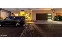 Beautiful single-story home with a modern garage door and well-manicured landscaping at twilight at 21 W Beryl Ave, Phoenix, AZ 85021