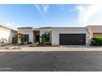 Charming single-story home with desert landscaping and a modern garage door under a blue sky at 21 W Beryl Ave, Phoenix, AZ 85021