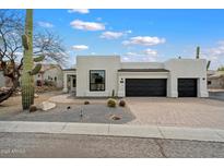 Stylish modern home with desert landscaping and two-car garage, under a partly cloudy sky at 28341 N 112Th Way, Scottsdale, AZ 85262
