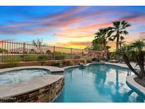 Inviting pool and spa with tropical landscaping create a relaxing backyard oasis at sunset at 3373 E Sports Dr, Gilbert, AZ 85298