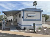 Charming mobile home with desert landscaping, covered porch, and a light blue trim on a sunny day at 4065 E University Dr # 88, Mesa, AZ 85205