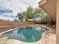 Backyard pool surrounded by desert landscaping, with rock features and shade trees at 5601 E Monte Cristo Ave, Scottsdale, AZ 85254
