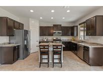 Beautiful kitchen with dark cabinets, granite countertops, island with seating, and stainless steel appliances at 608 E Pasaro Dr, Phoenix, AZ 85085