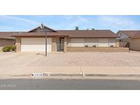 Charming single-story home featuring a two-car garage, low maintenance yard, and mature landscaping at 7310 E Dewberry Ave, Mesa, AZ 85208