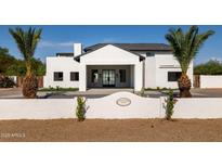 Stunning white home boasts modern design, desert landscaping, and a welcoming entryway with a tile roof at 10620 N 84Th St, Scottsdale, AZ 85260