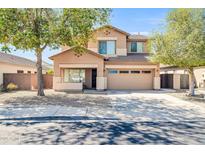 Inviting two-story home with a well-manicured front yard and attached two car garage at 14521 W Gelding Dr, Surprise, AZ 85379