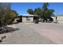 Charming single-story home featuring a cozy covered porch and well-maintained gravel landscaping at 1524 E 23Rd Ave, Apache Junction, AZ 85119