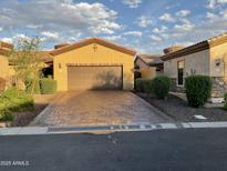 A single-Gathering home with a long brick driveway leading to a two-car garage with a neutral-colored exterior and terracotta roof at 2041 N 88Th St, Mesa, AZ 85207