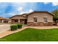 Charming single-story home showcasing appealing stone accents, manicured lawn and desert landscaping at 4255 S Marisol Ln, Gilbert, AZ 85297