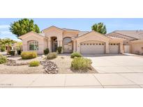 Charming single-story home featuring a three-car garage, landscaped front yard, and desert-friendly plantings at 6041 E Hartford Ave, Scottsdale, AZ 85254