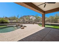 Relaxing backyard featuring a pool, putting green, desert landscaping, and mountain views at 11451 E Christmas Cholla Dr, Scottsdale, AZ 85255